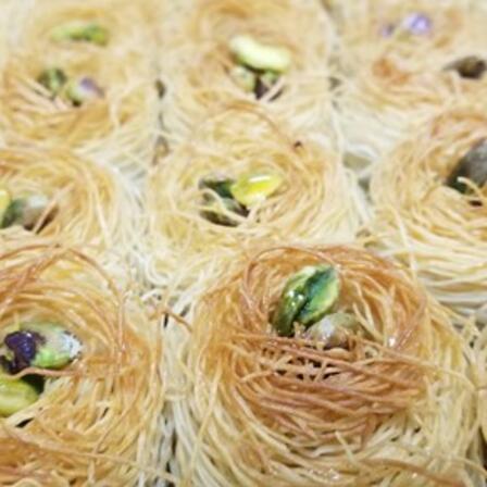 Bird Nest pastries by Ashikat Kitchen Pastries resembling a bird's nest with pistachios in the center by Ashikat Kitchen