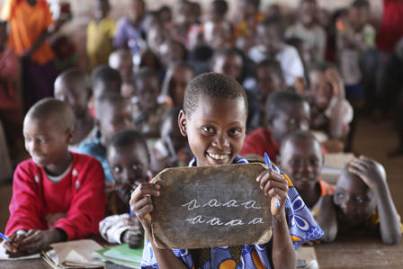 Children in Burundi practice their English letters at school.