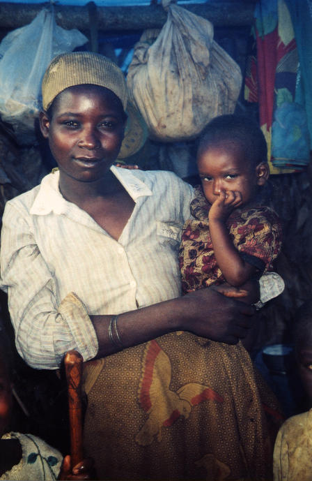 Angolan mother and child An Angolan woman stands and holds a small child as they look at the camera.