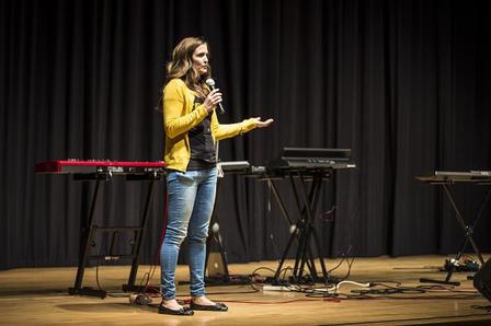 Claire Peterson, GenR Member, speaks before concert organized to benefit refugees Claire Peterson, GenR Member, speaks on stage before concert organized to benefit refugees