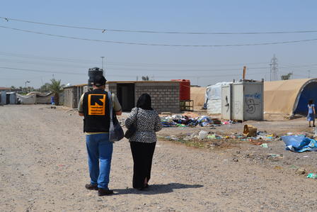 Community representatives walk through the camp