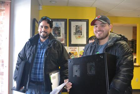 Tech mentor volunteer helps refugee set up and learn to use computer Tech mentor volunteer and refugee stand with computer hardware at the IRC in Salt Lake City