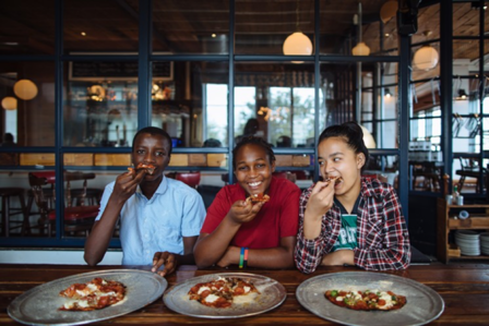 From left: Moise, Mariam and Pay Pay enjoy the pizza they made at Eno's Pizza Tavern as part of the Youth Food Justice Internship From left: Moise, Mariam and Pay Pay enjoy the pizza they made at Eno's Pizza Tavern as part of the Youth Food Justice Internship