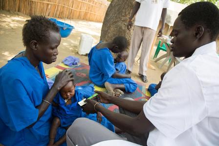 A health worker at an IRC-supported clinic in Ganyliel, South Sudan, measures a baby's arm to screen for malnutrition.