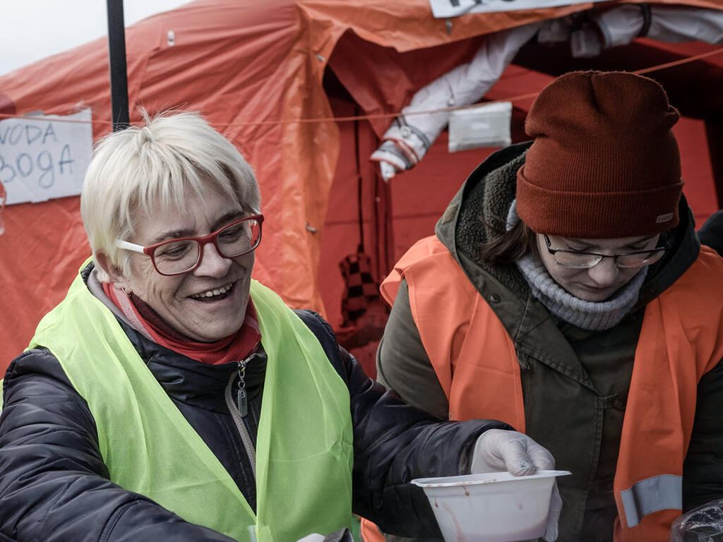 Volunteers distribute meals to Ukrainian refugees in Poland.