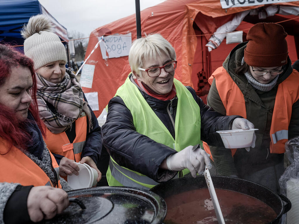 Volunteers distribute meals to Ukrainian refugees in Poland.
