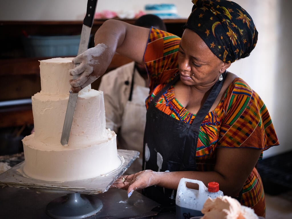 Woman decorating a cake.