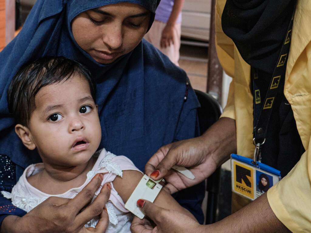 En sjuksköterska från RESCUE mäter överarmen på Hajera Bibi, 2 år, vid en klinik i ett flyktingläger utanför Cox’s Bazar, Bangladesh.