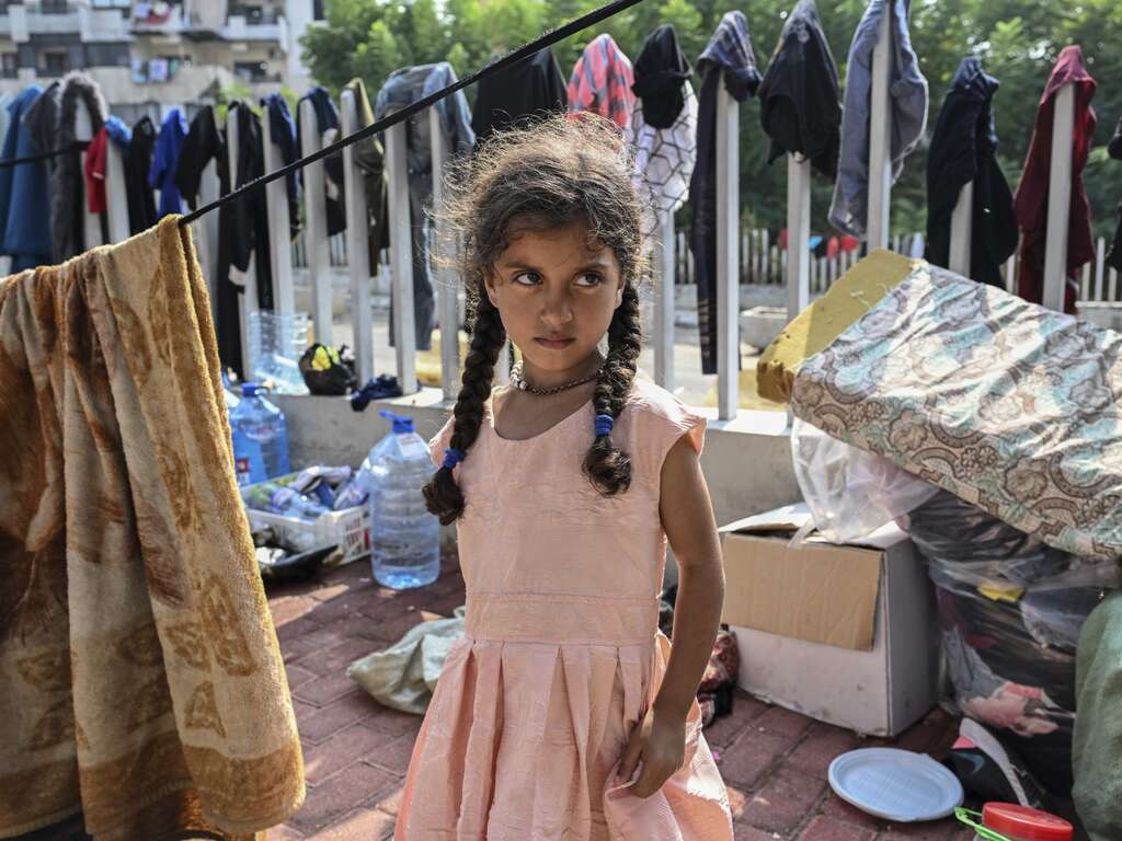 어린 난민 소녀가 베이루트 거리에 앉아 있습니다.