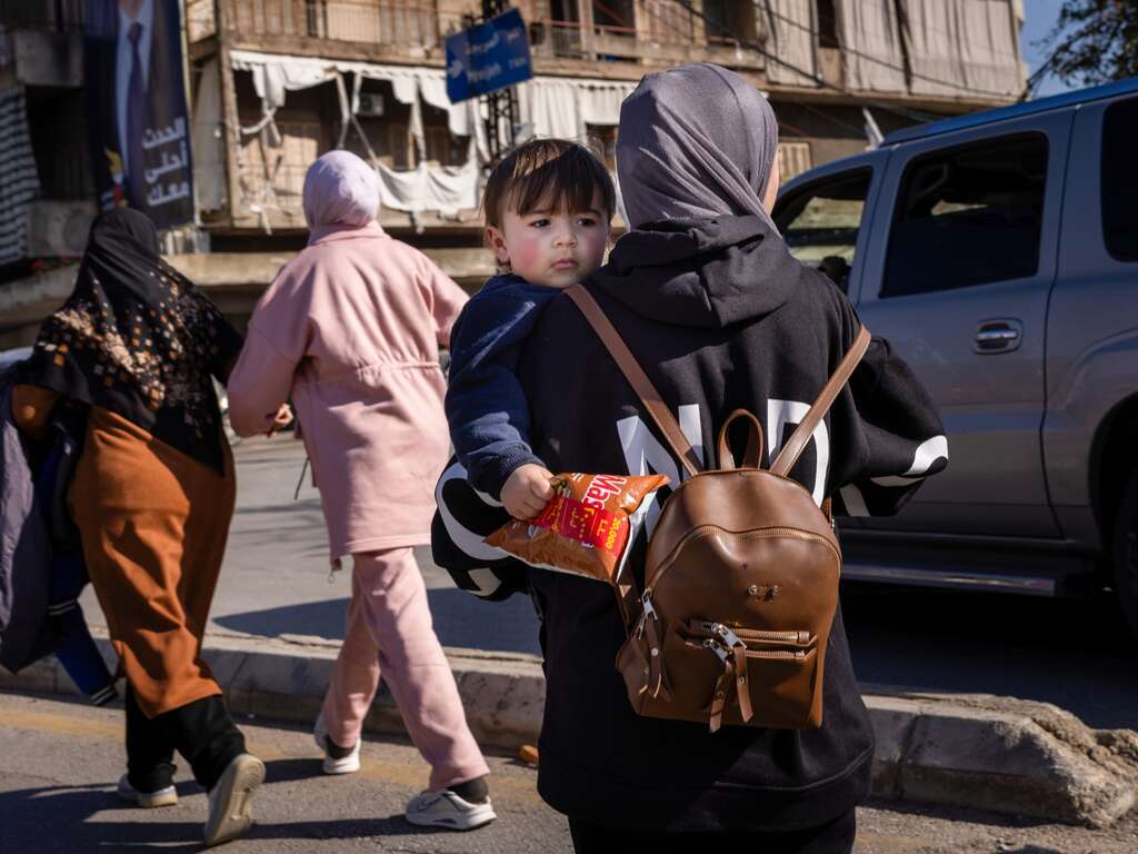 A young boy and his mother walk through the streets of Beirut, Lebanon.