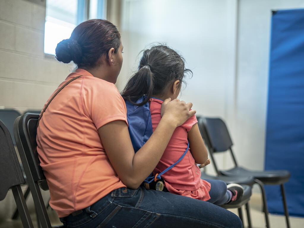 Emilia sits with her arms around four-year-old Lauda in a shelter in Phoenix, Arizona for asylum-seeking families who were released from detention at the U.S. border