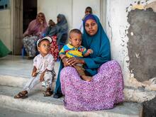 Eine Mutter wartet mit ihren zwei Kindern und weiteren Menschen vor dem Krankenhaus in Karaan, Somalia