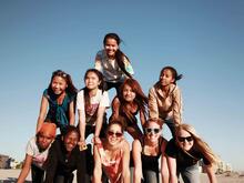 Teilnehmer*innen von International Rescue Committees „Girls Group“ an den Strand bilden eine Pyramide am Strand in San Diego. 