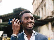 A man holding his phone speaker to his ear.