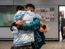 Two men hug at an airport