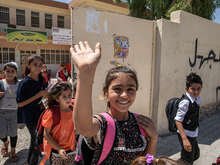 Darin, en ung flicka från Sinjar, Iraq, vinkar utanför sin skola.