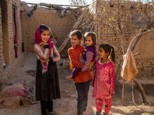 Four girls pose for a photo in an outdoors courtyard.