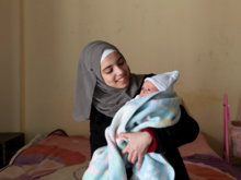Sabah, 15, holds her newborn brother Mustafa. Sabah’s family are Syrian refugees living in Lebanon. 