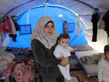 A mother holds her child at a shelter in Syria.