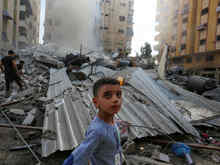 People assess the destruction cause by Israeli air strikes in Gaza City on October 7, 2023.