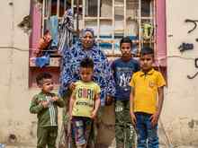 A family stands outside of a building, posing for a photo.