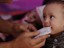 Ett litet barn blir matad med nötkräm.