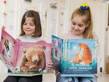 Two Ukrainian children sit by side reading books recently translated into Ukrainian and provided by the IRC.