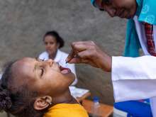A child receives an oral vaccination from a health worker in Ethiopia.
