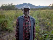 A man standing in the middle of a field and smiling into the camera