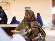 Eine Mutter hält ihr schlafendes Kind in den Armen, während sie eine IRC-Gesundheitsklinik in Somalia besucht.