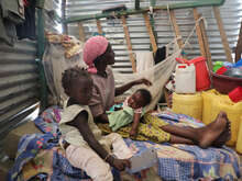 클라우딘이 자신의 작은 집 안에서 아이들과 함께 앉아 있습니다.