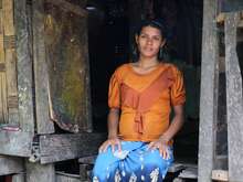 A woman sits on the steps of her home in Myanmar as her portrait is taken.