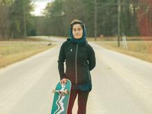 A 22-year-old Afghan woman holds her skateboard