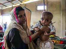 A Rohingya refugee woman holds her malnourished baby in an IRC-supported health center in Bangladesh.