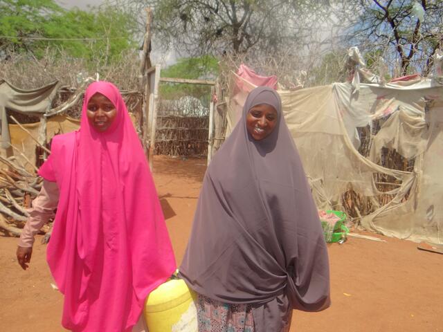 Two women carrying a jerrycan