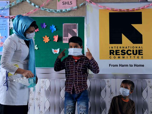 IRC-Hygienebeauftragte Sohalia zeigt Kindern in Afghanistan, wie sie einen Mund-Nasen-Schutz benutzen. 