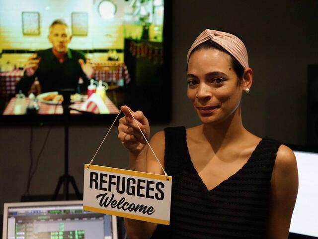 Yasmin Kadi hält ein Schild in die Höhe auf dem "Refugees Welcome" steht.