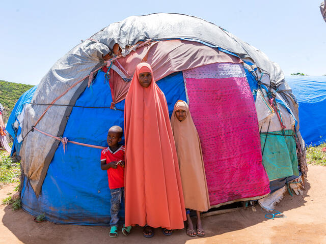 Misra standing in front of her tent with her children