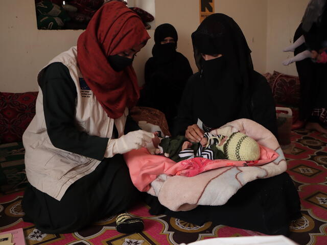 Dr. Bushra attending to a client and her baby during a field visit