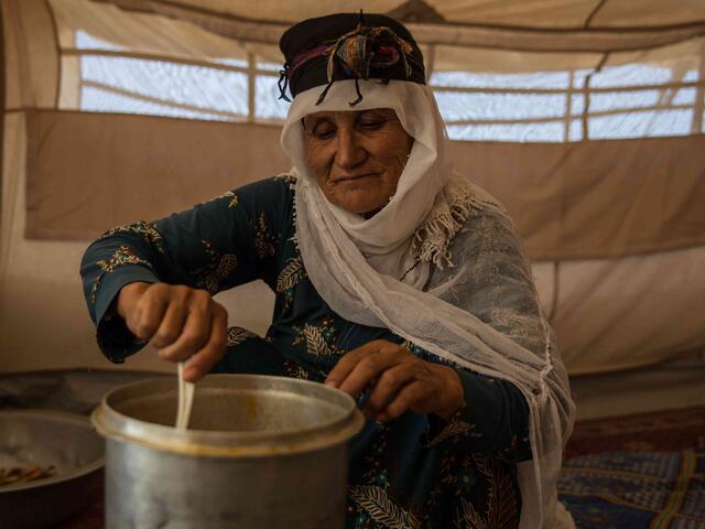 Babona aus Afghanistan rührt in einem Topf.