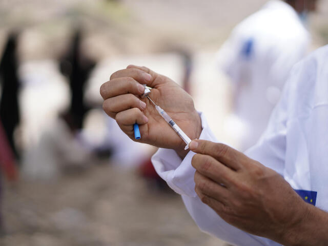 Close up of doctors hands holding a syringe