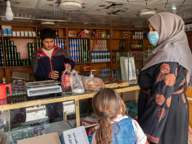 A mother and daughter buying food from a local market