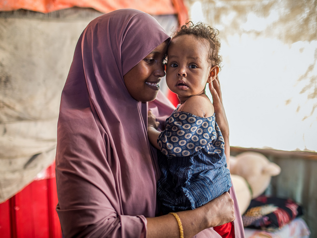 Maryan, vårdarbetare för RESCUE, håller i hennes elva månader gamla dotter Sagal.