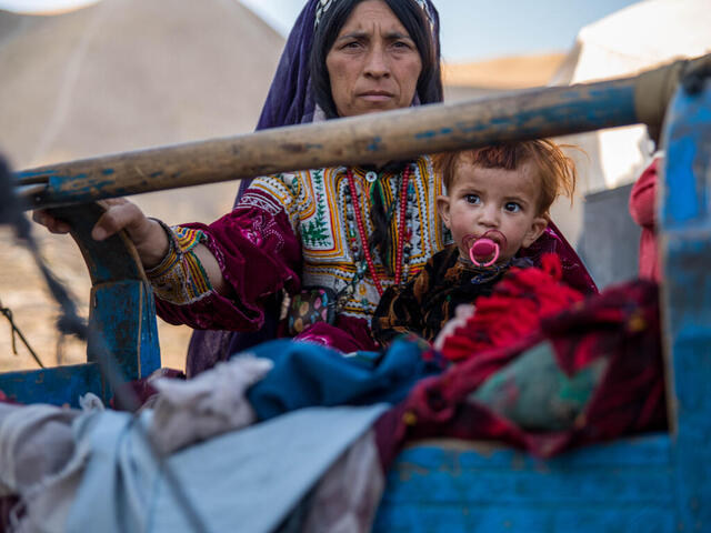 A woman and her child pose for a photo, outdoors in Afghanistan.