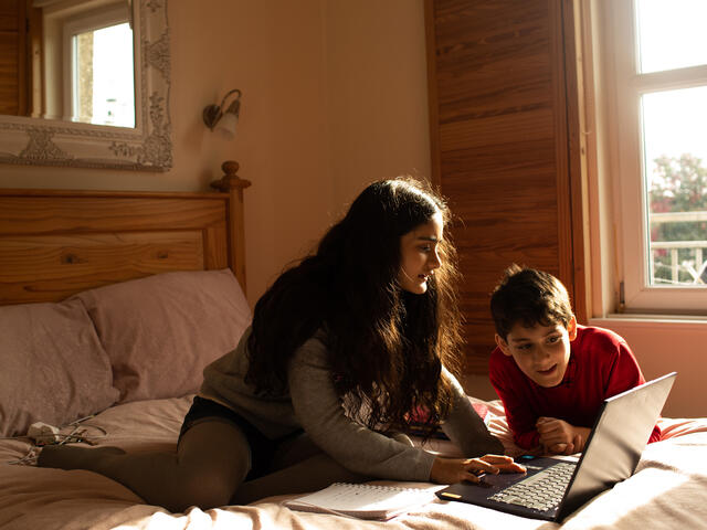 IRC client Zahra's children Beheena and Zain do their homework on their mums bed.
