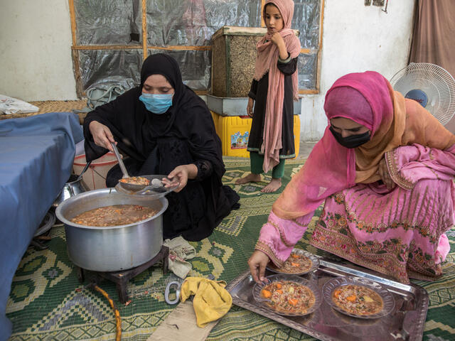 Barfi, IRC community health surveillance assistant leads a cooking class helped by Rahullah (in pink), IRC Community Health Volunteer