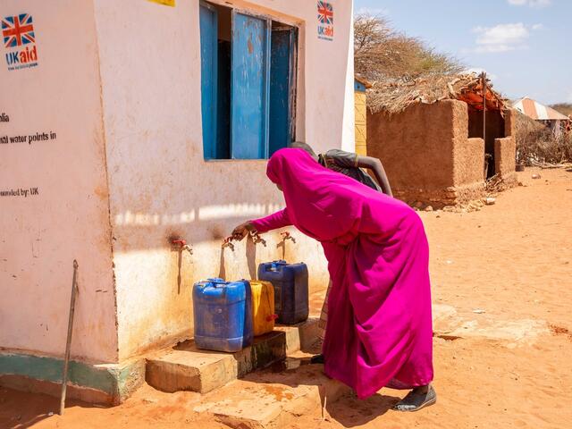 A woman collecting water at an IRC-installed pump