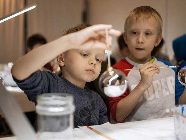 Two small Ukrainian boys decorating Christmas ornaments