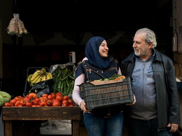 Photo of Ala'a carrying a crate of vegetables