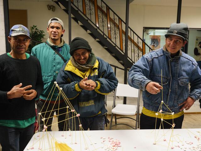 Iván exhibits his work to the group at the end of the IRC masculinity session: a tower made of spaghetti and marshmallow, with an antenna for the extra singularity.